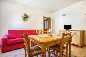 a living room with a wooden table and a red couch at Agritur piazera con terrazzo in Ronzo Chienis