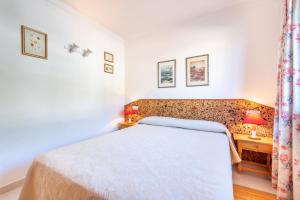 a bedroom with a white bed and a desk at Delta 3 in Sóller