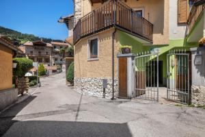 a building with a balcony on the side of a street at Agritur piazera con terrazzo in Ronzo Chienis