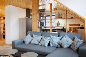 a living room with a blue couch with pillows at Wohnung Karin in Spalt