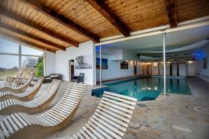 a house with a swimming pool with chairs around it at Landhaus Ostseeblick Fewo 5 - in Kronsgaard