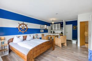 a bedroom with a bed with a blue and white wall at Landhaus Ostseeblick Fewo 5 - in Kronsgaard +26 photos