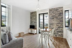 a living room with a table and a stone wall at Vila Francisco in Funchal
