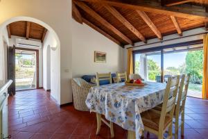 a kitchen and dining room with a table and chairs at Villa Sabbia - Private pool in Stintino