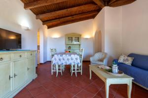 a living room with a table and a blue couch at Villa Sabbia - Private pool in Stintino