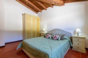a bedroom with a blue bed and a wooden cabinet at Villa Sabbia - Private pool in Stintino +25 photos