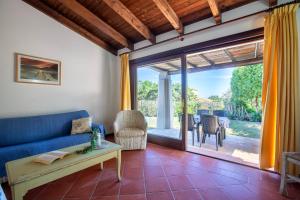 a living room with a blue couch and a table at Villa Sabbia - Private pool in Stintino