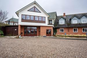 a large house with a driveway in front of it at Landhaus Ostseeblick Fewo 5 - in Kronsgaard