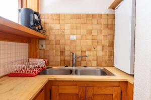 a kitchen sink with a red basket next to it at La Bévéria in Pralognan-la-Vanoise +34 photos