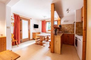 a kitchen with wooden cabinets and a table in it at La Bévéria in Pralognan-la-Vanoise
