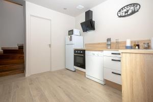 a kitchen with white cabinets and a refrigerator at Gite La Maison Du Soyeux Ga in Les Abrets en Dauphine