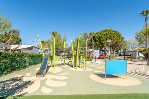 a park with a playground with a slide at Mobilhomelaco34 in Vendres