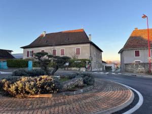 a street with two houses and a tree in the middle at Gite La Maison Du Soyeux Ga in Les Abrets en Dauphine