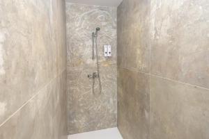 a shower in a bathroom with a stone wall at Gite La Maison Du Soyeux Ga in Les Abrets en Dauphine +6 photos