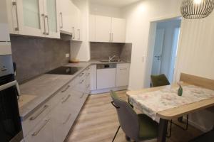 a kitchen with white cabinets and a table with chairs at Ferienwohnung am Stadtwall in Stockach