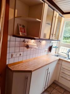 a small kitchen with a sink and white cabinets at Extertal Ferienpark Haus Sonnental in Extertal +37 photos