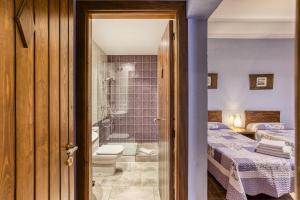 a bathroom with a shower and a bedroom with two beds at Casa Rural El Torn in Garriguella +30 photos