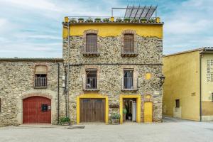 an old stone building with doors and windows at Casa Rural El Torn in Garriguella