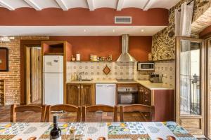 a kitchen with a table and chairs and a refrigerator at Casa Rural El Torn in Garriguella
