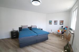 a bedroom with a blue bed in a white room at Ferienwohnung am Stadtwall in Stockach