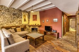 a living room with a couch and a fireplace at Casa Rural El Torn in Garriguella