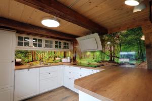 a kitchen with white cabinets and a painting on the wall at Ferienhütte Biobetrieb Lippenhof in Bruckbach +26 photos