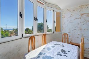 a dining room with a table and four windows at Casa Santana in Vecindario