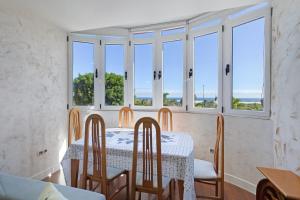 a dining room with a table and chairs and windows at Casa Santana in Vecindario
