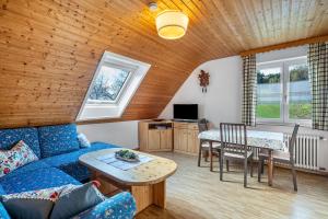 a living room with a blue couch and a table at Dorerhof Prechtal in Elzach