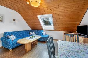 a living room with a blue couch and a table at Dorerhof Prechtal in Elzach