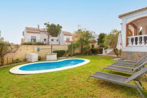 a backyard with a swimming pool and a house at Casa Guadalmar in Málaga