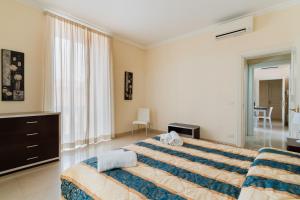 a bedroom with a bed and a dresser and a window at Palazzo Mongiò in Gallipoli +242 photos