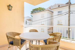 a table and chairs on a balcony with a view of a building at Talaia 1a in Port de Pollensa