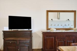 a flat screen tv on a dresser with a mirror at Il Podere Del Ponti - Paduletto in Casa Paduletto