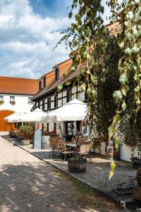 a group of tables and chairs in front of a building at Weingut Schuh in Coswig