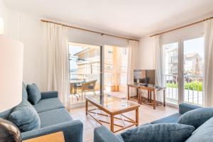 a living room with a couch and a table at Talaia 1a in Port de Pollensa