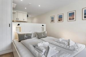a large white bed with pillows on it in a room at Wohnung Früger in Westerland