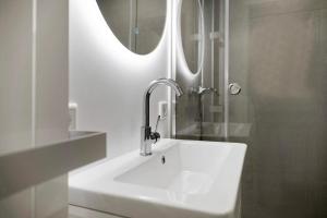 a white sink in a bathroom with a mirror at Wohnung Früger in Westerland +18 photos