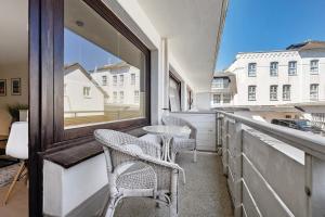 a balcony with chairs and a table and a window at Wohnung Früger in Westerland