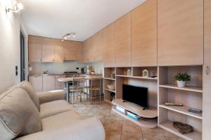 a living room with a couch and a tv and a kitchen at Il nido del lago in Carriola