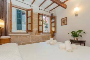 a bedroom with a large white bed and windows at Ses Andrones 3 in Ciutadella