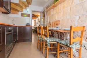 a kitchen with a table and chairs and a stone wall at Ses Andrones 3 in Ciutadella +19 photos