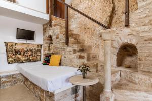 a room with a bed in a stone wall at Vrahos Tinos in Panormos