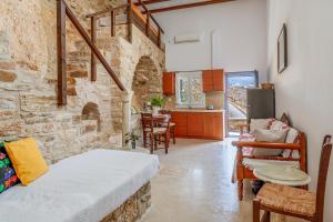 a living room with a stone wall at Vrahos Tinos in Panormos