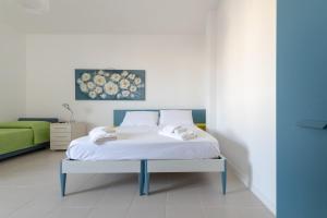 a bedroom with a white bed with a blue frame at Dimora lungomare terra d'otranto in Otranto