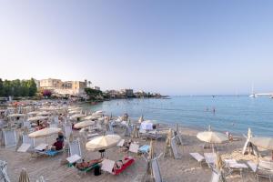 a beach with chairs and umbrellas and people on the beach at Dimora lungomare terra d'otranto in Otranto