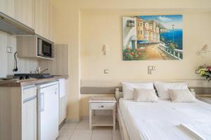 a bedroom with a white bed and a painting on the wall at Nontas Home 22 in Kalamitsi