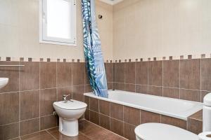 a bathroom with a toilet and a blue fish shower curtain at Casa Axarquia in Vélez-Málaga +18 photos