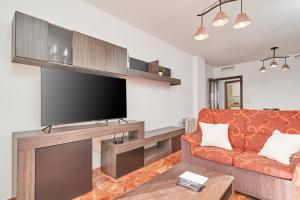 a living room with a couch and a flat screen tv at Casa Axarquia in Vélez-Málaga