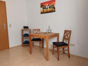 a wooden table with two chairs and a cat on a wall at Apartment Schwär in Endingen